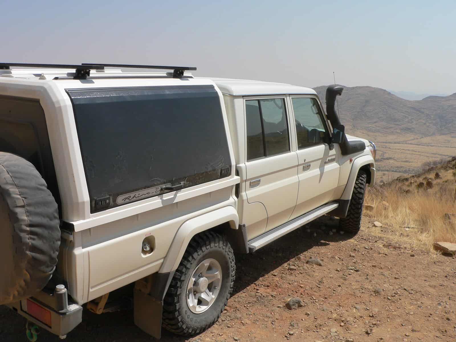 Weißer Landcruiser 4x4 Mietwagen in Namibia in der weiten Wüste Namibias in der Rückansicht