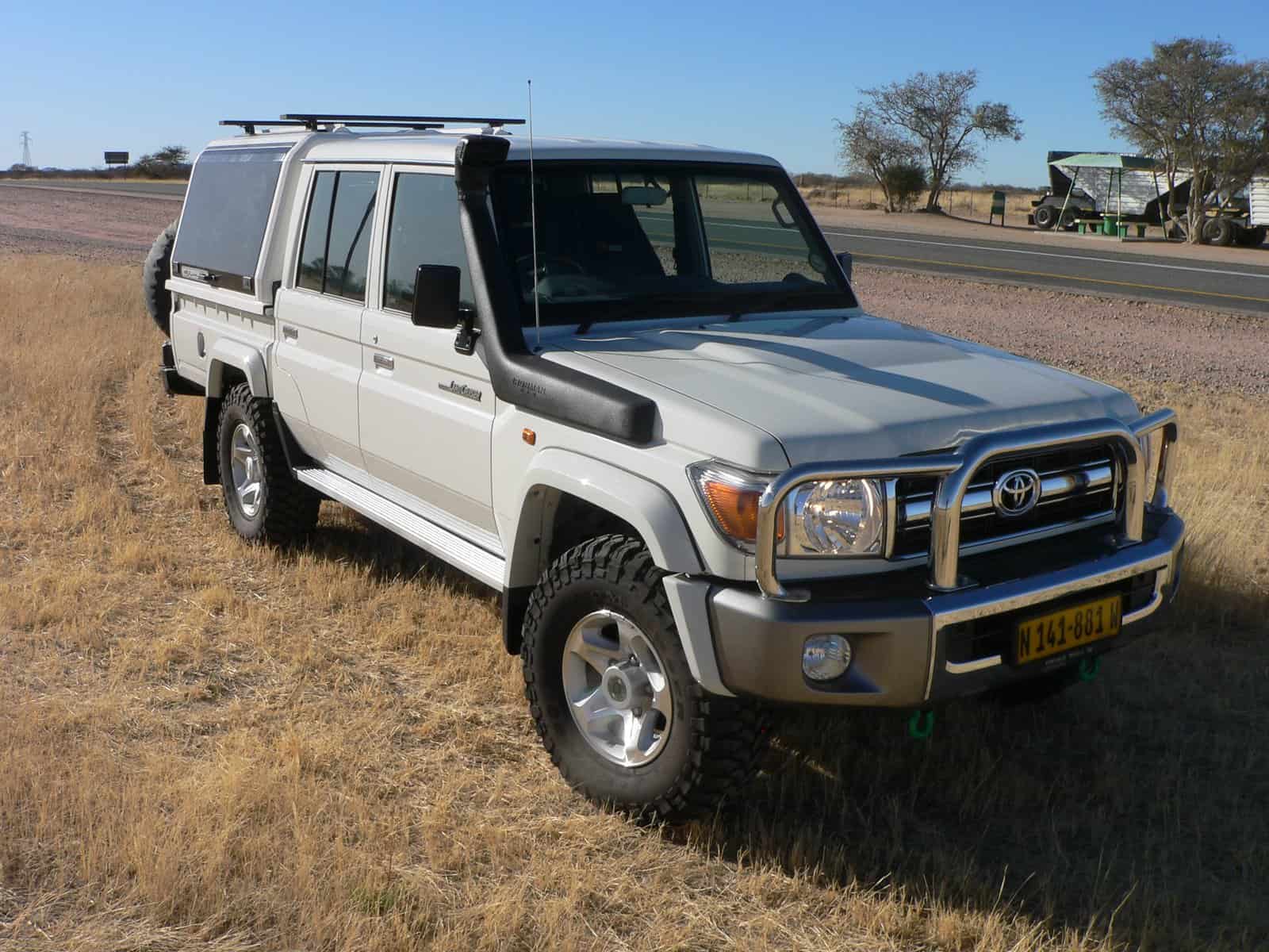 Weißer Landcruiser 4x4 Mietwagen in Namibia in der weiten Wüste Namibias in der Frontansicht