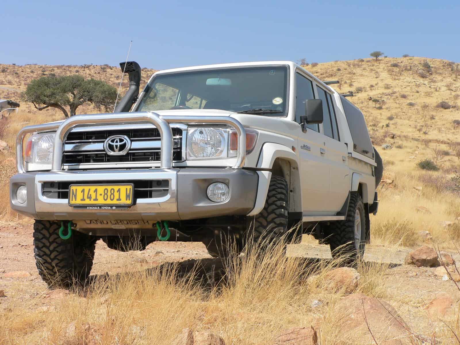 Weißer Landcruiser 4x4 Mietwagen in Namibia in der weiten Wüste Namibias in der Frontansicht