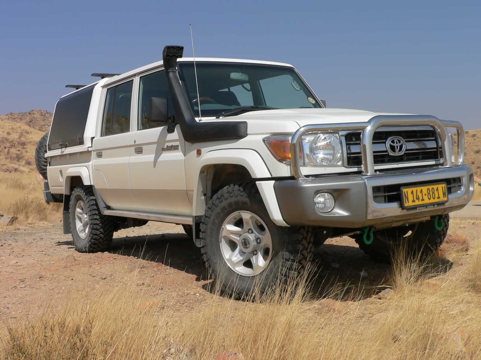 Weißer Landcruiser 4x4 Mietwagen in Namibia in der weiten Wüste Namibias in der Frontansicht